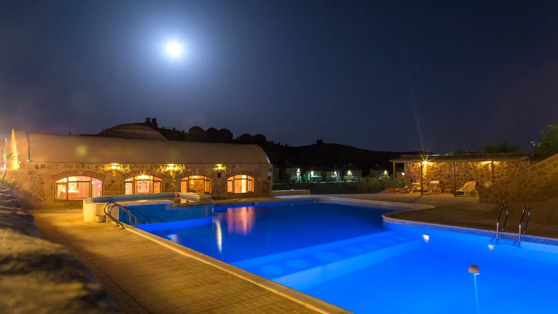 Freshwater swimming pool at Roots Red Sea illuminated at night